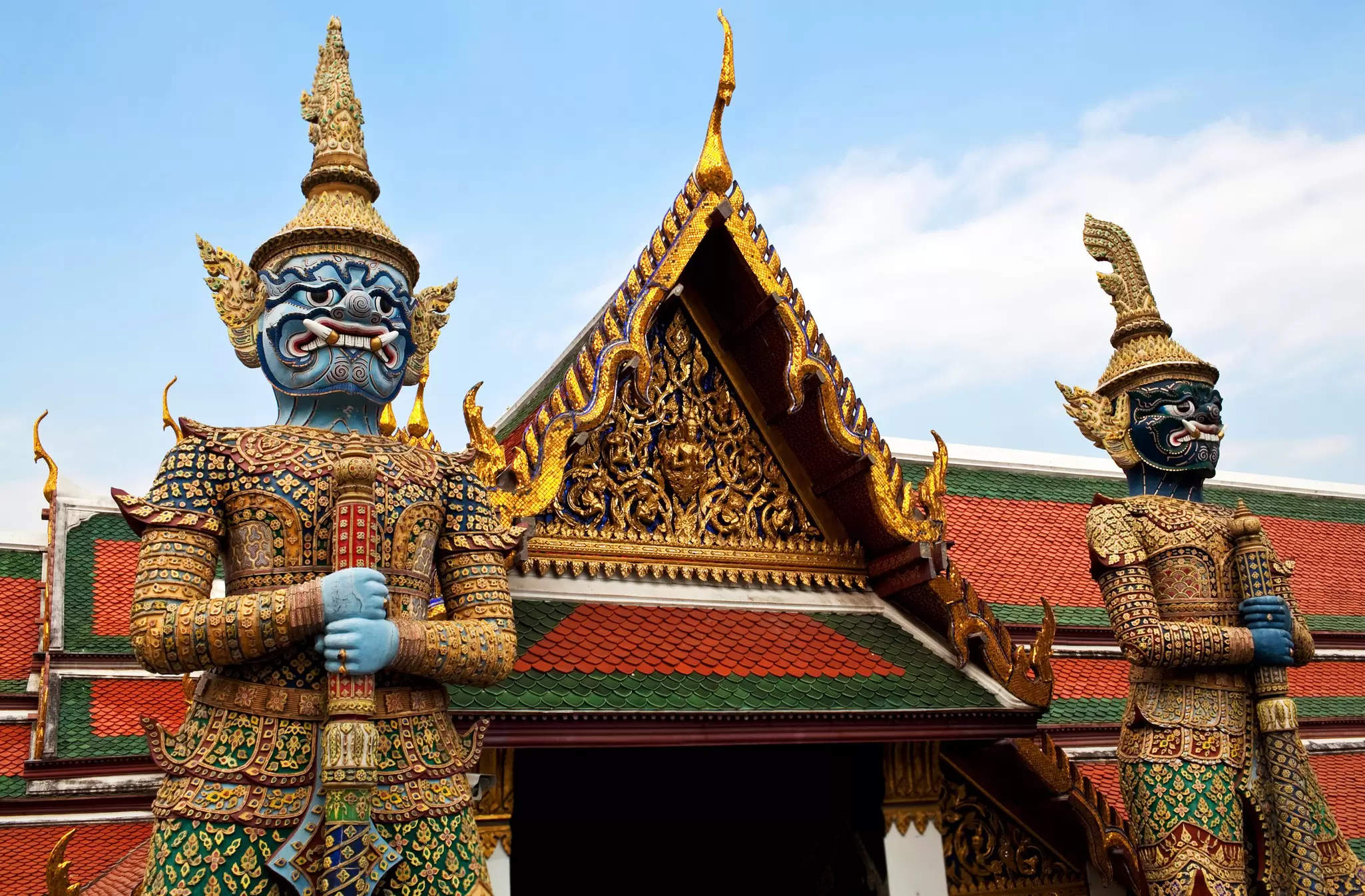 View of giant statues of Yaksha guarding an exit to Wat Phra Kaew in Bangkok, Thailand.