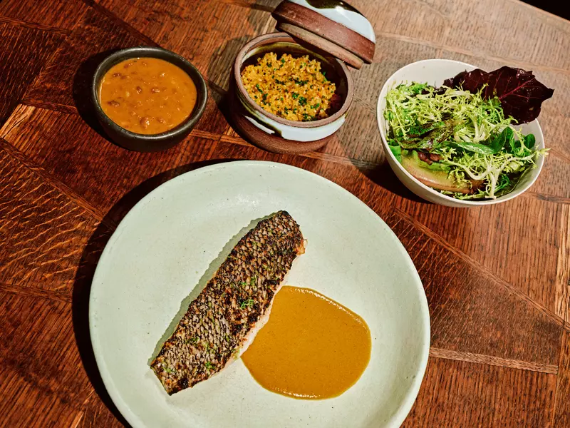 Black bass served with curry, yellow rice, and a side salad at Kabawa in the East Village, NYC
August 2025