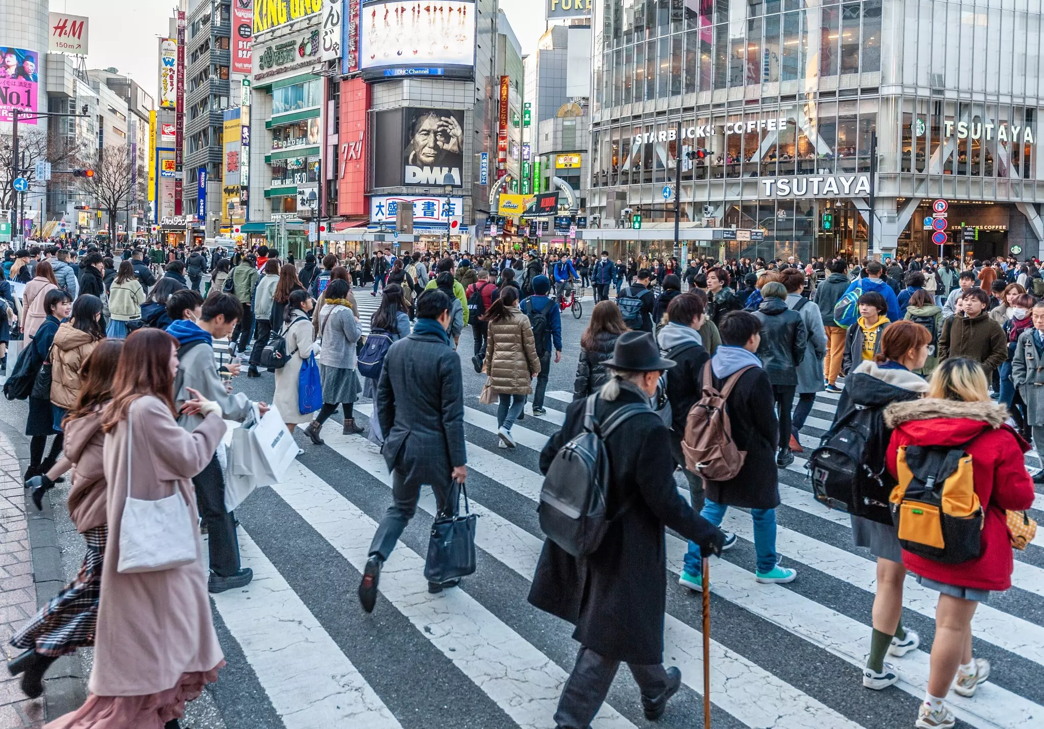 Many people walking through a busy intersection in Tokyo.