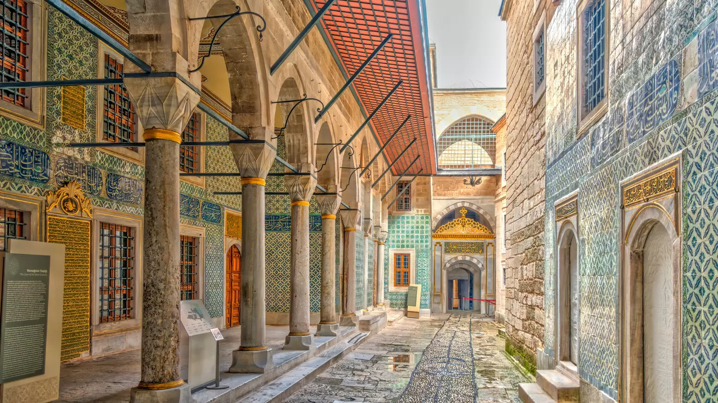Narrow alleyway between buildings with tile-covered exteriors.