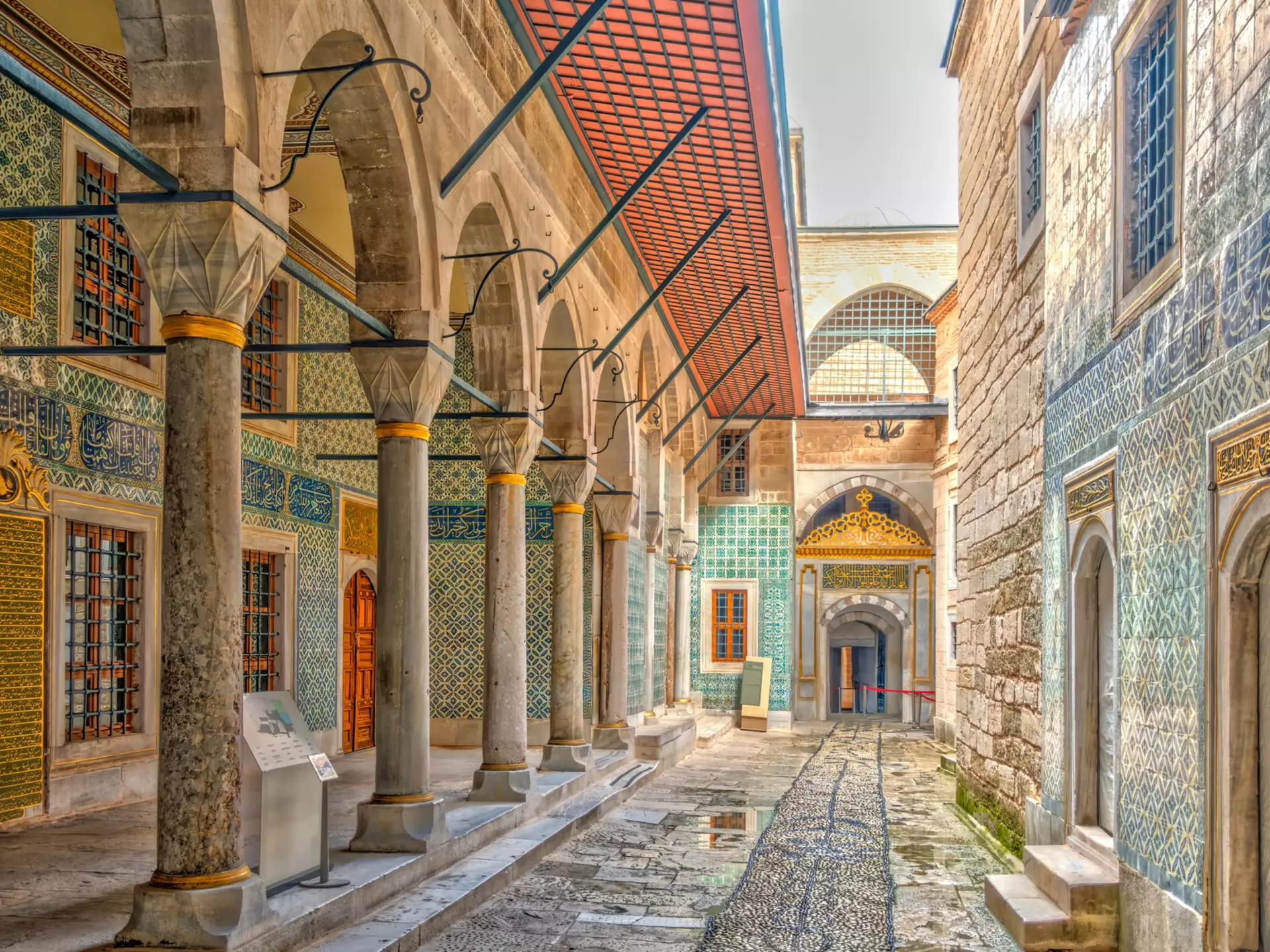 Narrow alleyway between buildings with tile-covered exteriors.