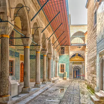 Narrow alleyway between buildings with tile-covered exteriors.