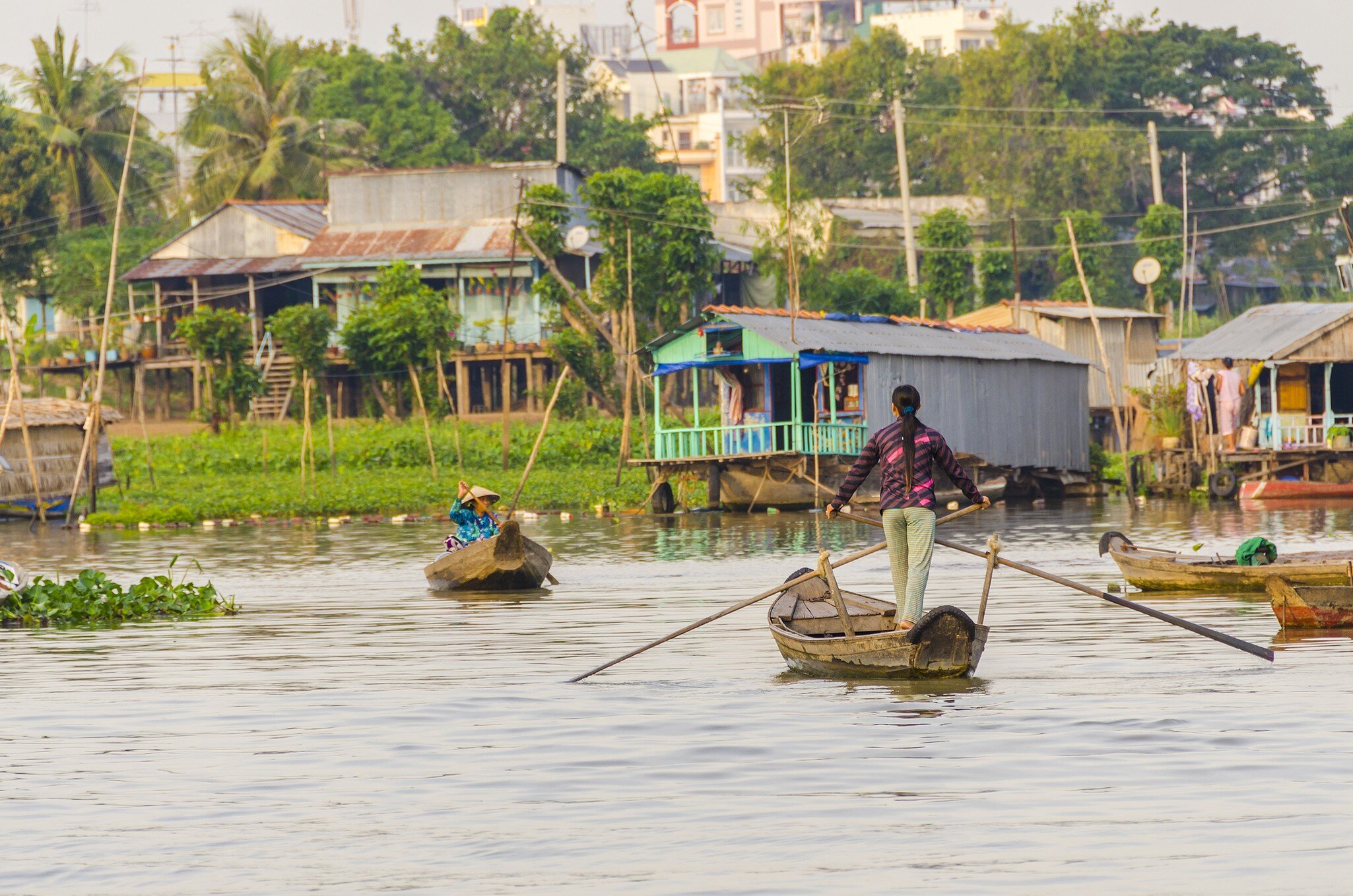 Local women on boats by the floating village on Hau River in Chau Doc in the Mekong Delta.