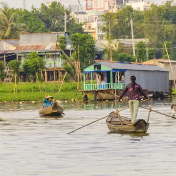 Local women on boats by the floating village on Hau River in Chau Doc in the Mekong Delta.