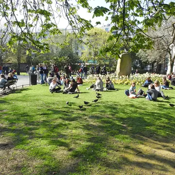 Crowds relaxing on the grass at St Stephen's Green park in central Dublin on a sunny day