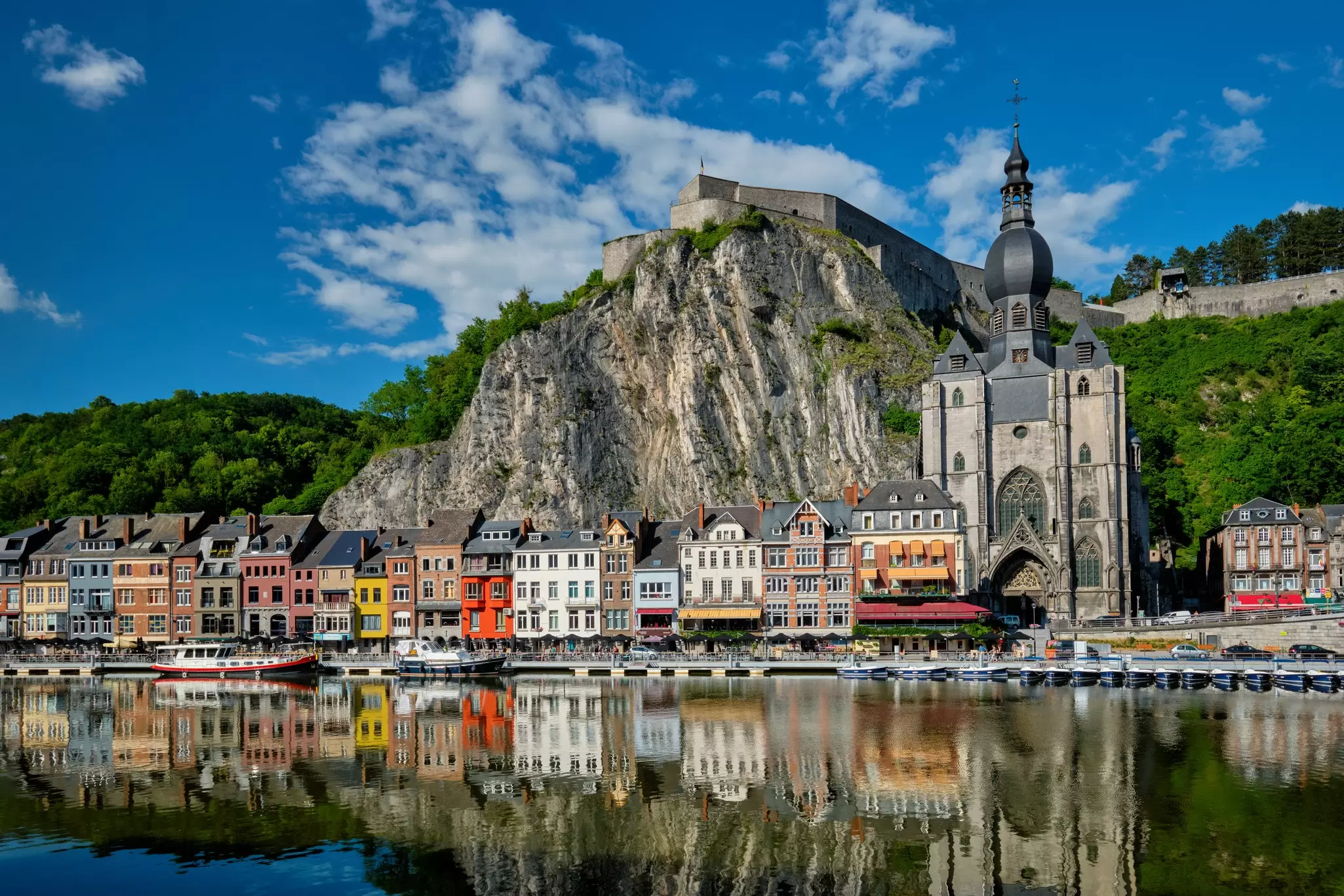 A fortress on a hill above a town along a river.