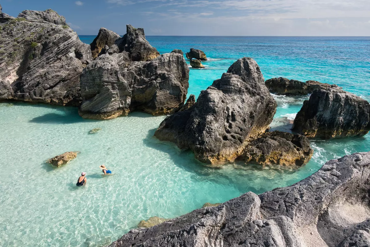 Tourists enjoying the crystal clear waters of the Atlantic Ocean at the world famous Horseshoe Bay Beach, Bermuda