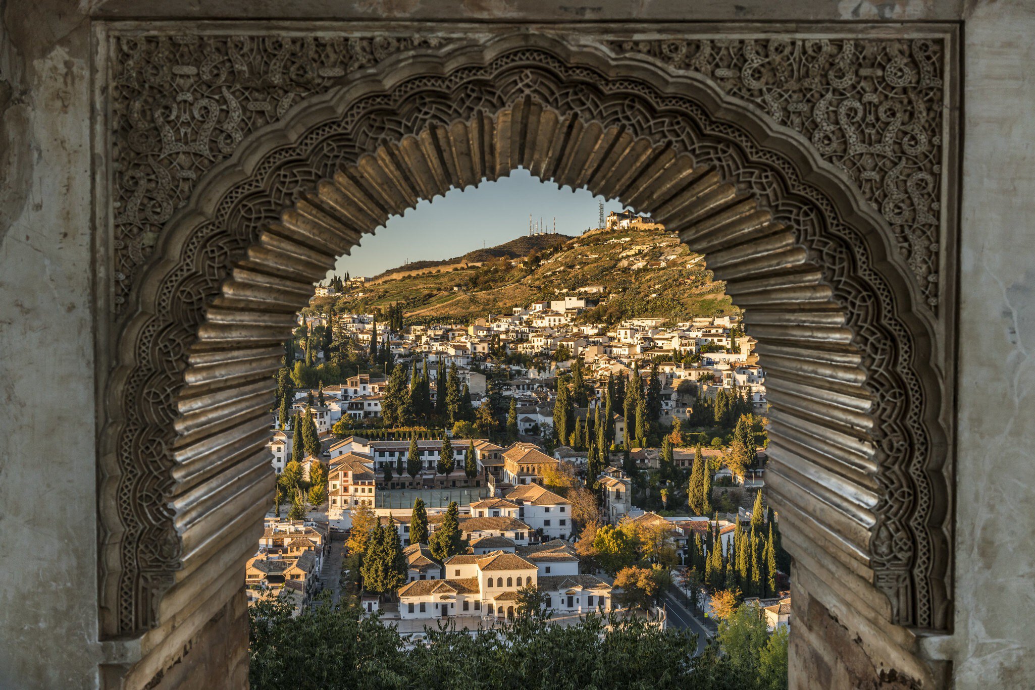 View of the Albayzin district of Granada, Spain, from a window in the Alhambra palace near sunset.