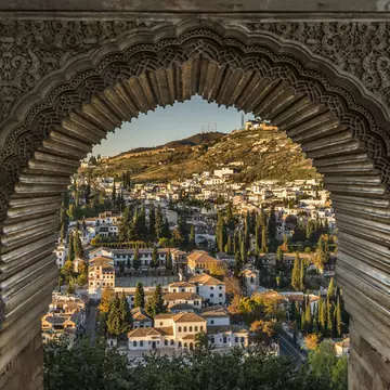 View of the Albayzin district of Granada, Spain, from a window in the Alhambra palace near sunset.