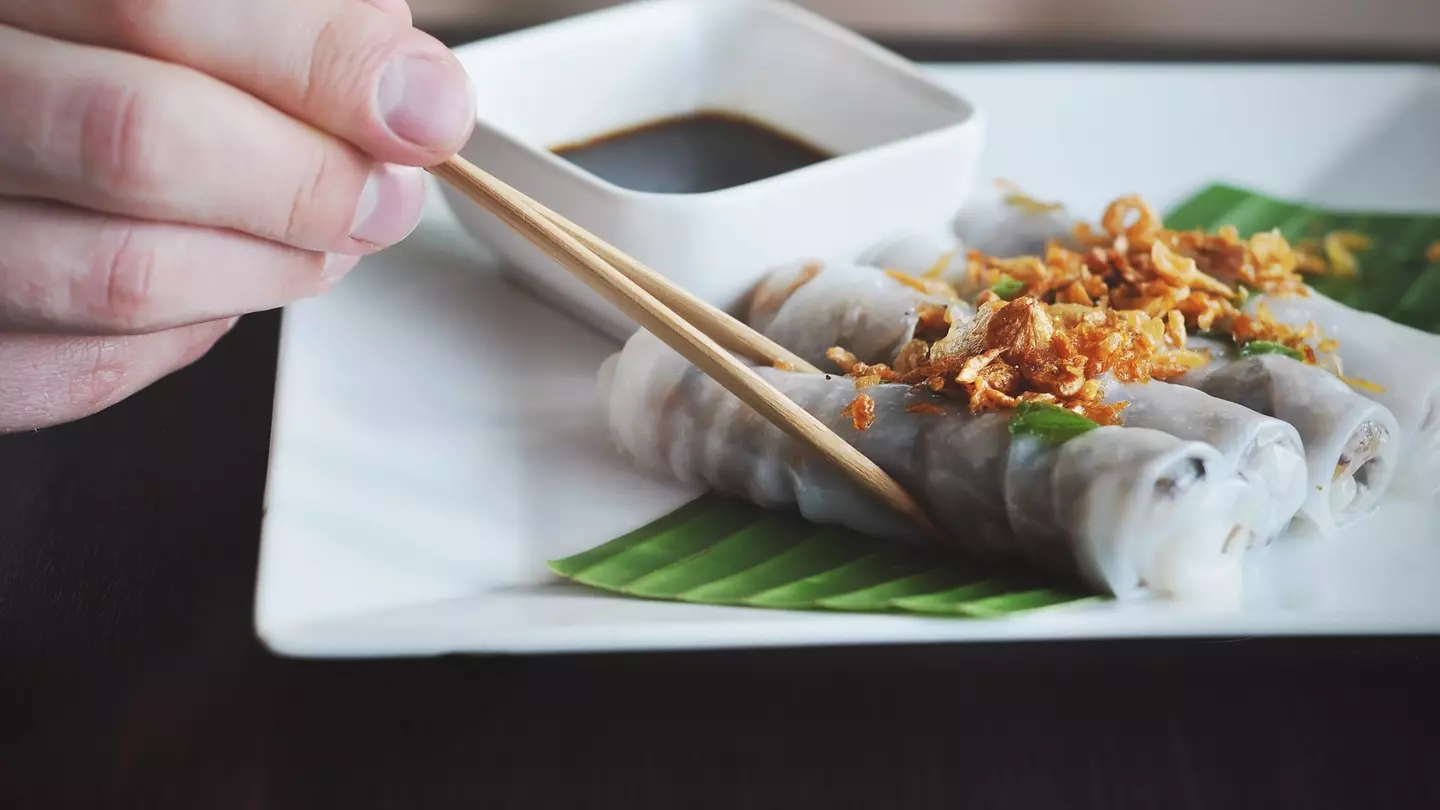 close up of shrimp and sausage gumbo in a cast-iron pot on a wooden table