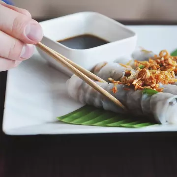 close up of shrimp and sausage gumbo in a cast-iron pot on a wooden table