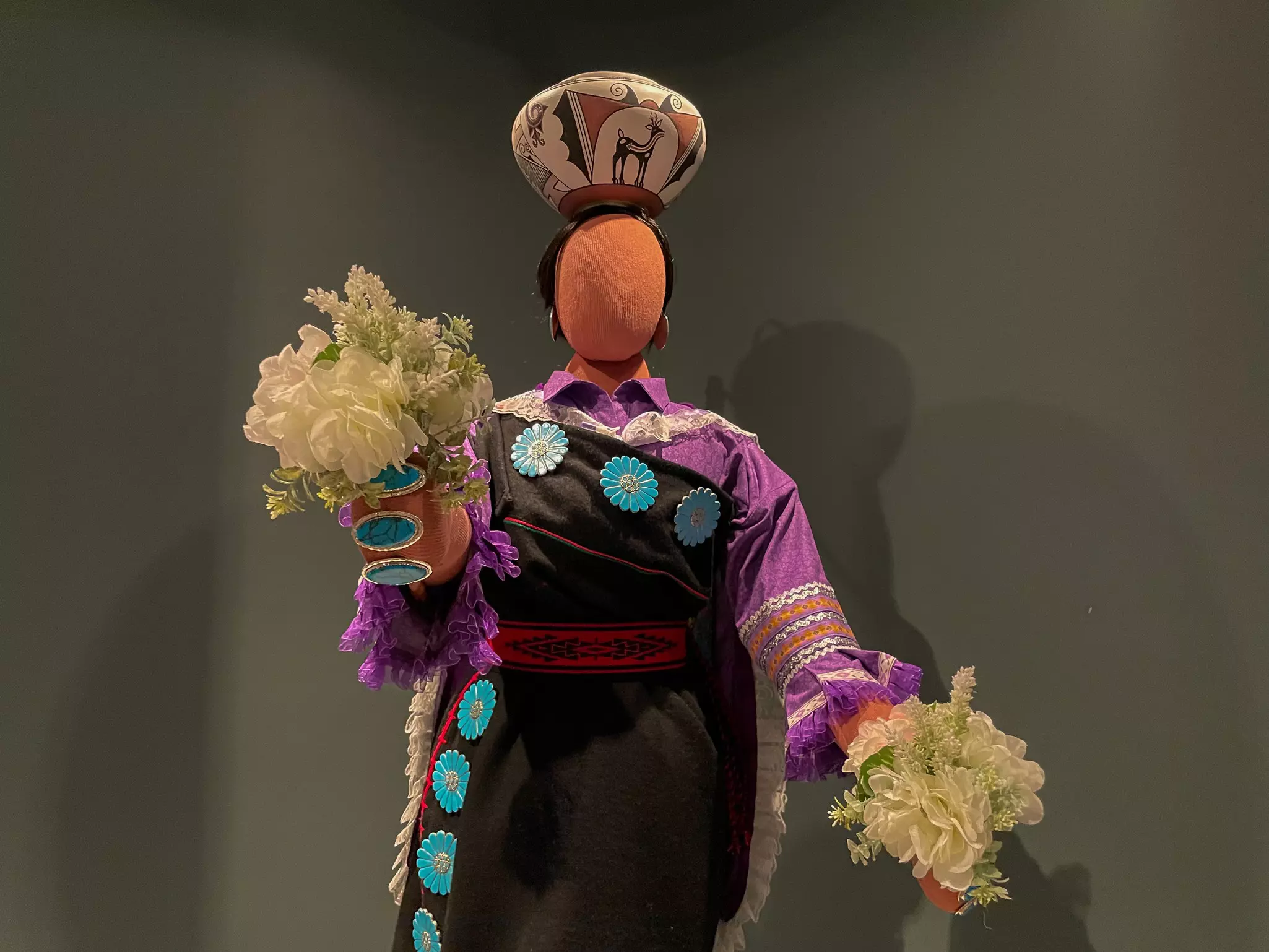 A Roman amphiteatre with some houses and the top of the basilica in the background