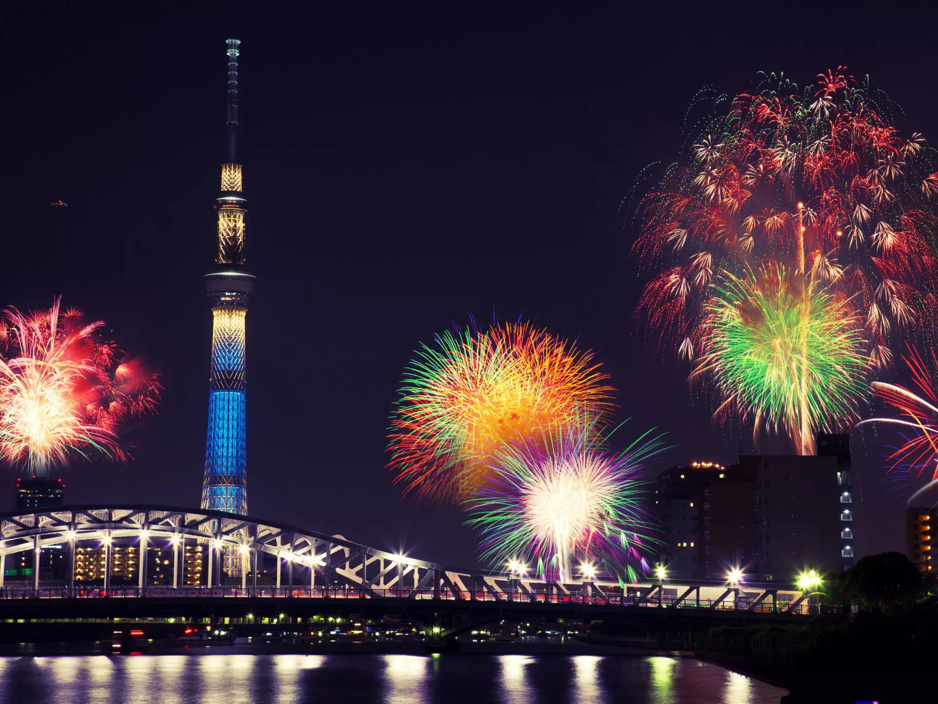 Summer fireworks over the Sumida river at night in Tokyo, Japan