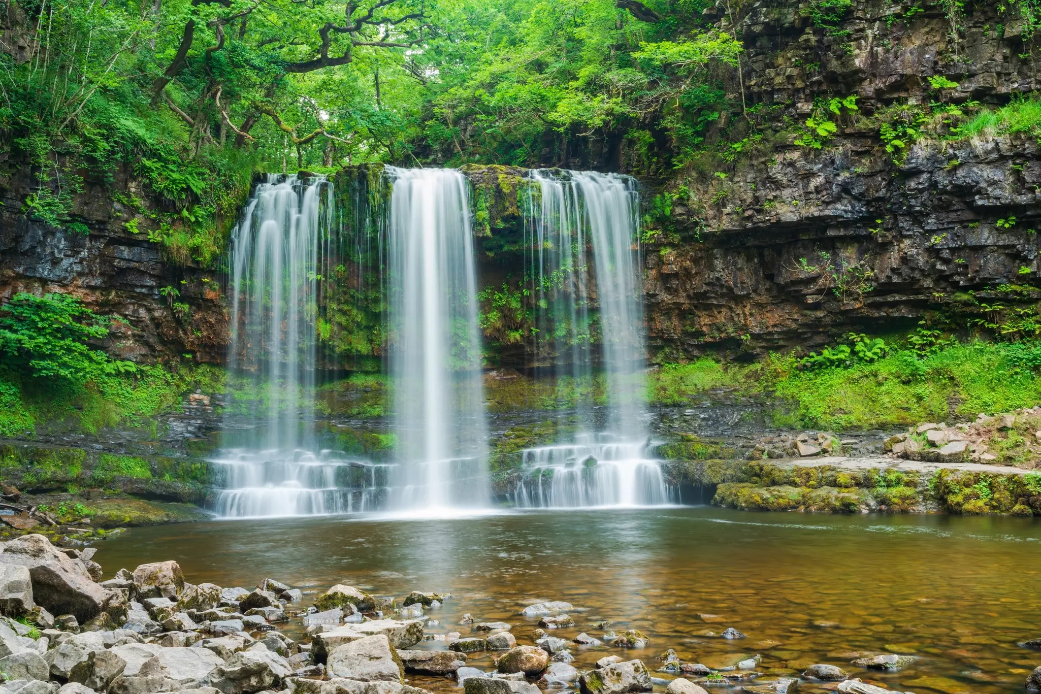 A waterfall plunges into a pool