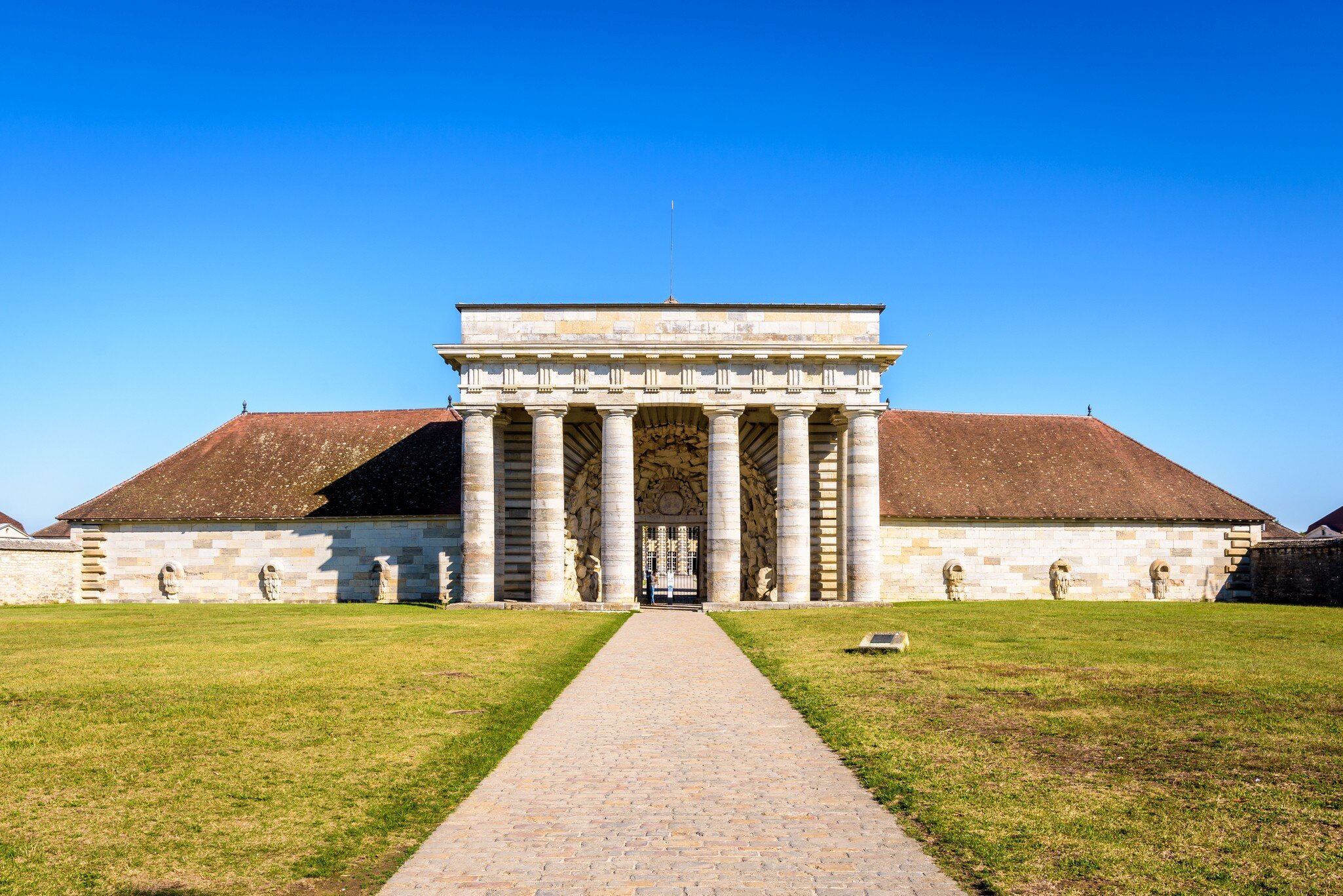 Arc-et-Senans, France - September 1, 2020: Front view of the southern facade of the former Guards building of the Royal Saltworks, with a neoclassical portico, only entrance to the site.
