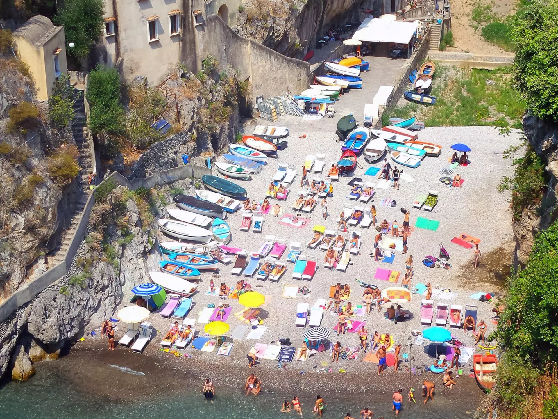 People swim the clear blue waters on a small beach in Ravello, Italy. 