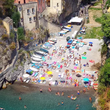 People swim the clear blue waters on a small beach in Ravello, Italy. 