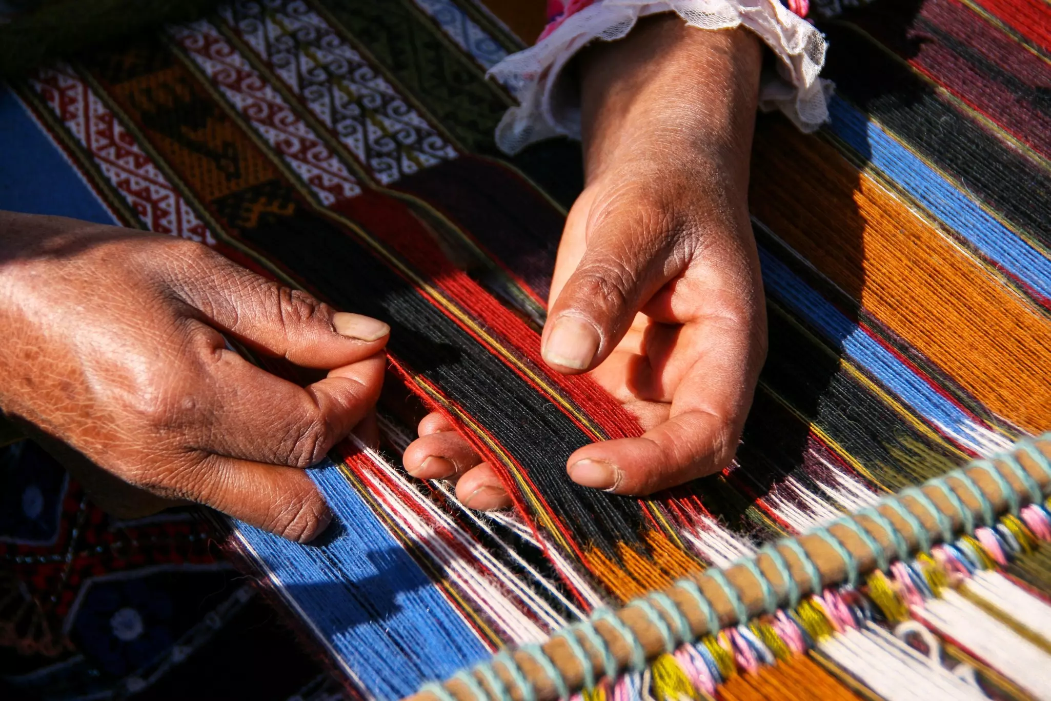 Woman's hands in Peru weaving wool
