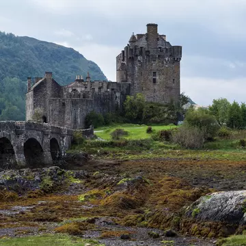 Eilean Donan Castle and its stone arched bridge in the misty Scottish Highlands