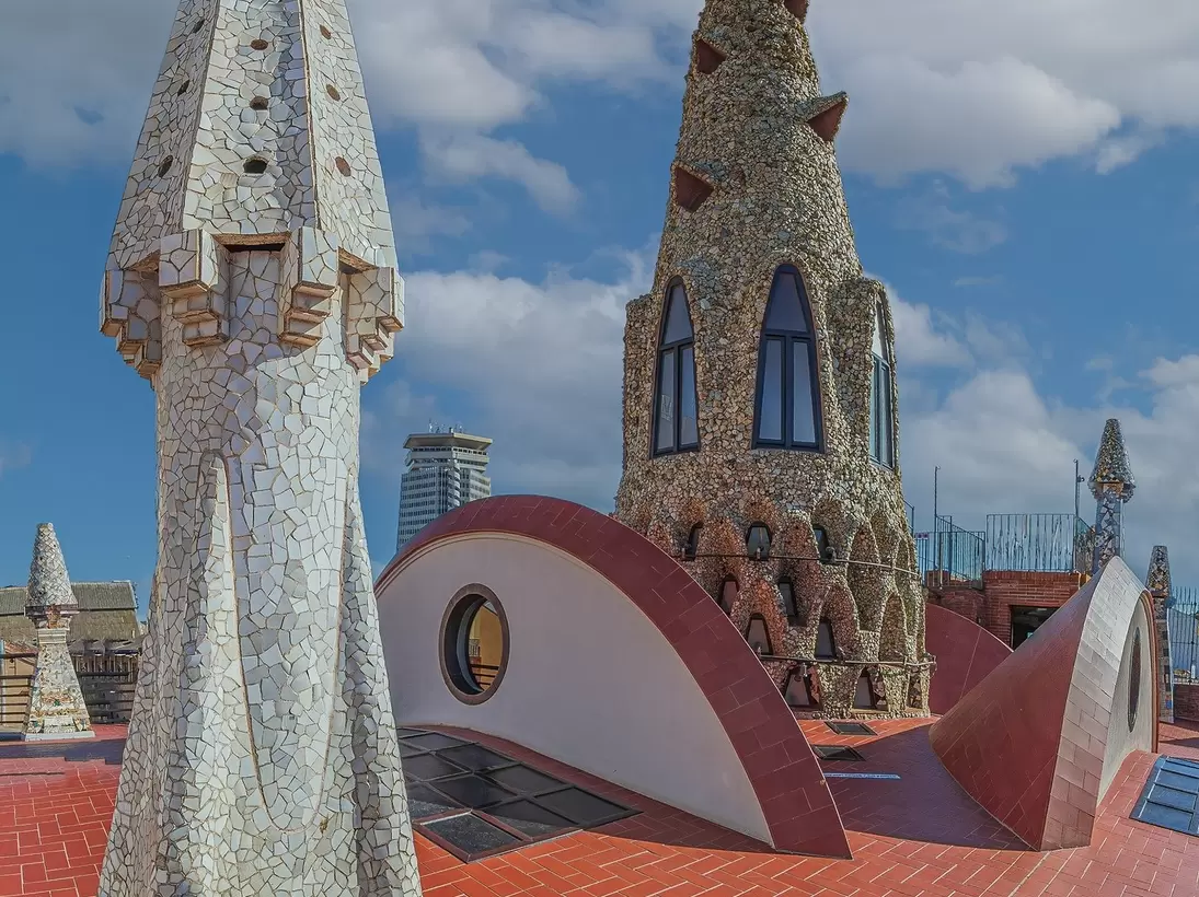 Original chimneys covered with ceramics of different colors on the roof of the Palaü Guell in Barcelona, Spain.