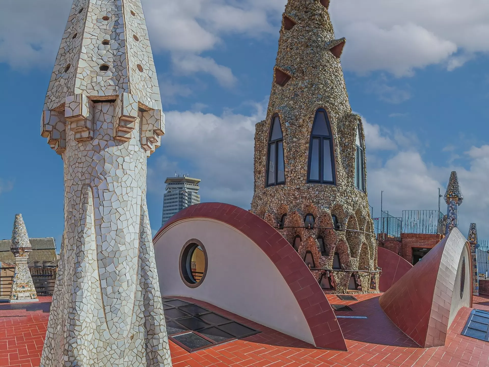 BARCELONA, SPAIN - APRIL 14, 2024: Original chimneys covered with ceramics of different colors on the roof of the Palau Guell designed by architect Antoni Gaudi. Built 1886-1888, UNESCO.