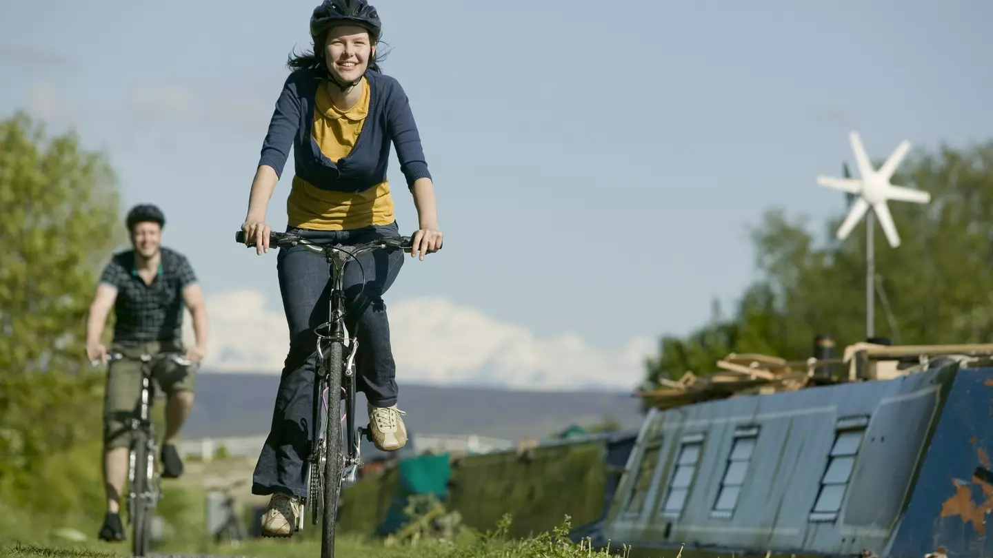 Couple cycling along canal towpath near Glasson Dock in Lancashire, England, United Kingdom