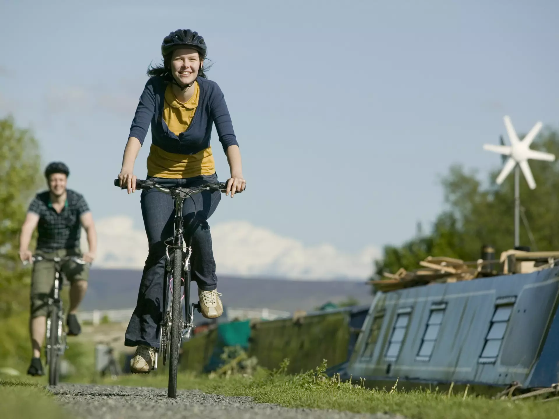 Couple cycling along canal towpath near Glasson Dock in Lancashire, England, United Kingdom