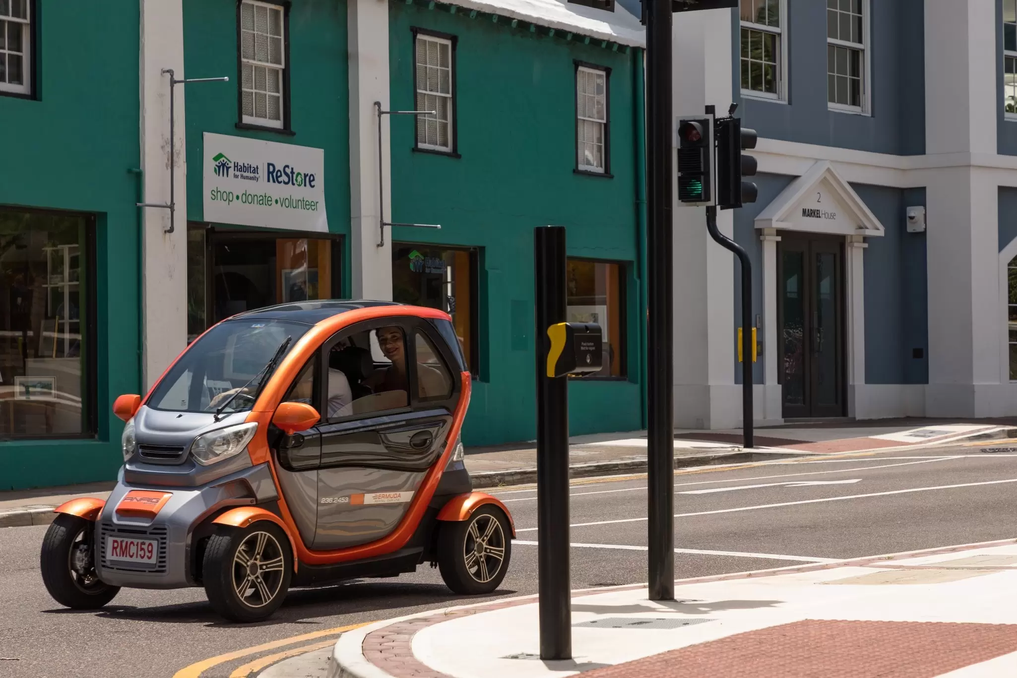 A Twizy microcar stopped at traffic lights on a city street