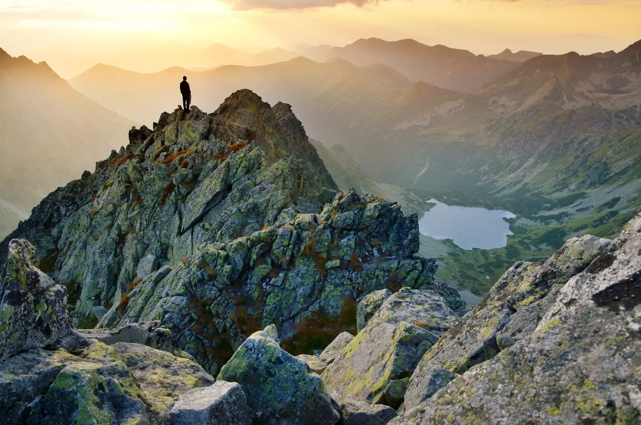 Hiker watching scenery in mountains during sunset in High Tatras in Slovakia