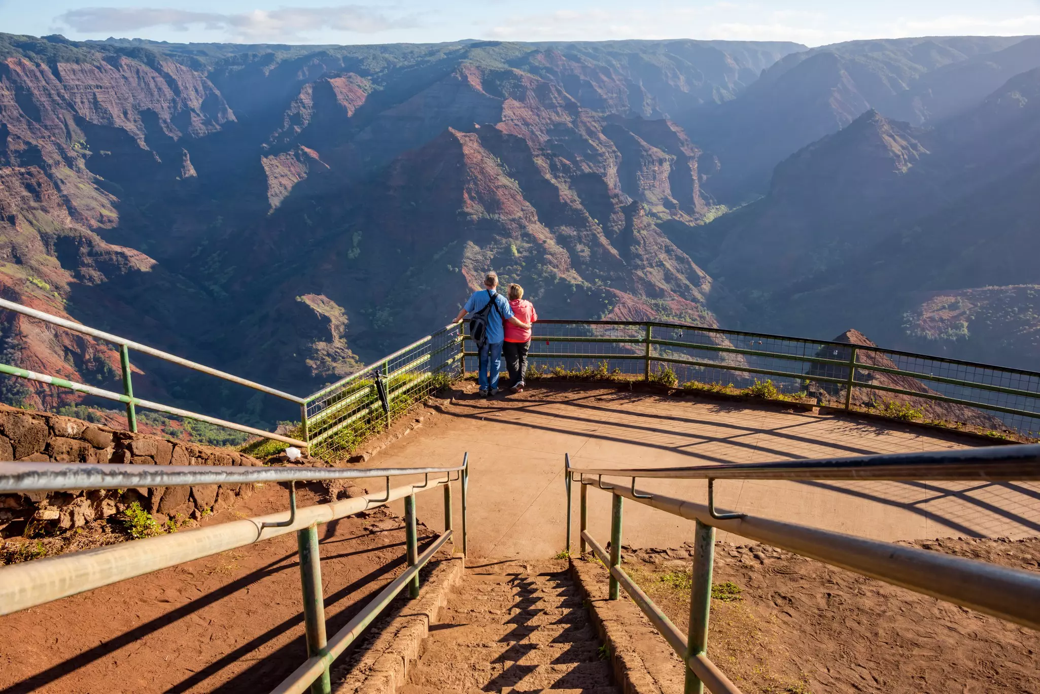 A couple enjoying views of Waimea Canyon from a lookout point