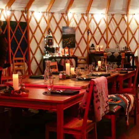 The inside of the yurt with candles and blankets. 
