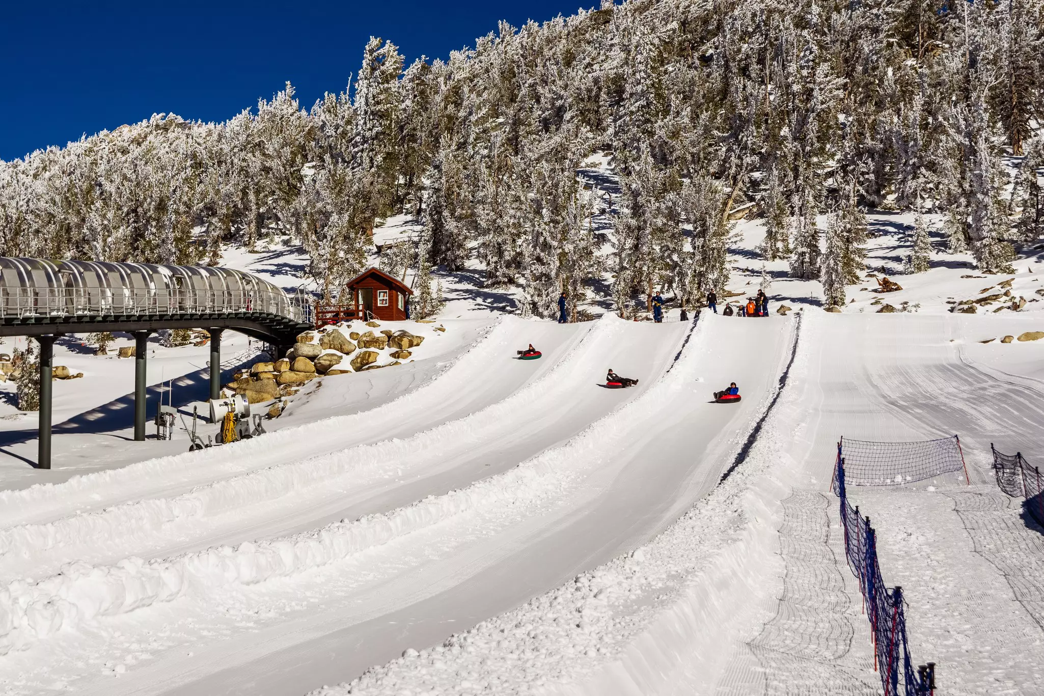 Tourists tubing on the slopes of Heavenly Ski Resort on a sunny winter day