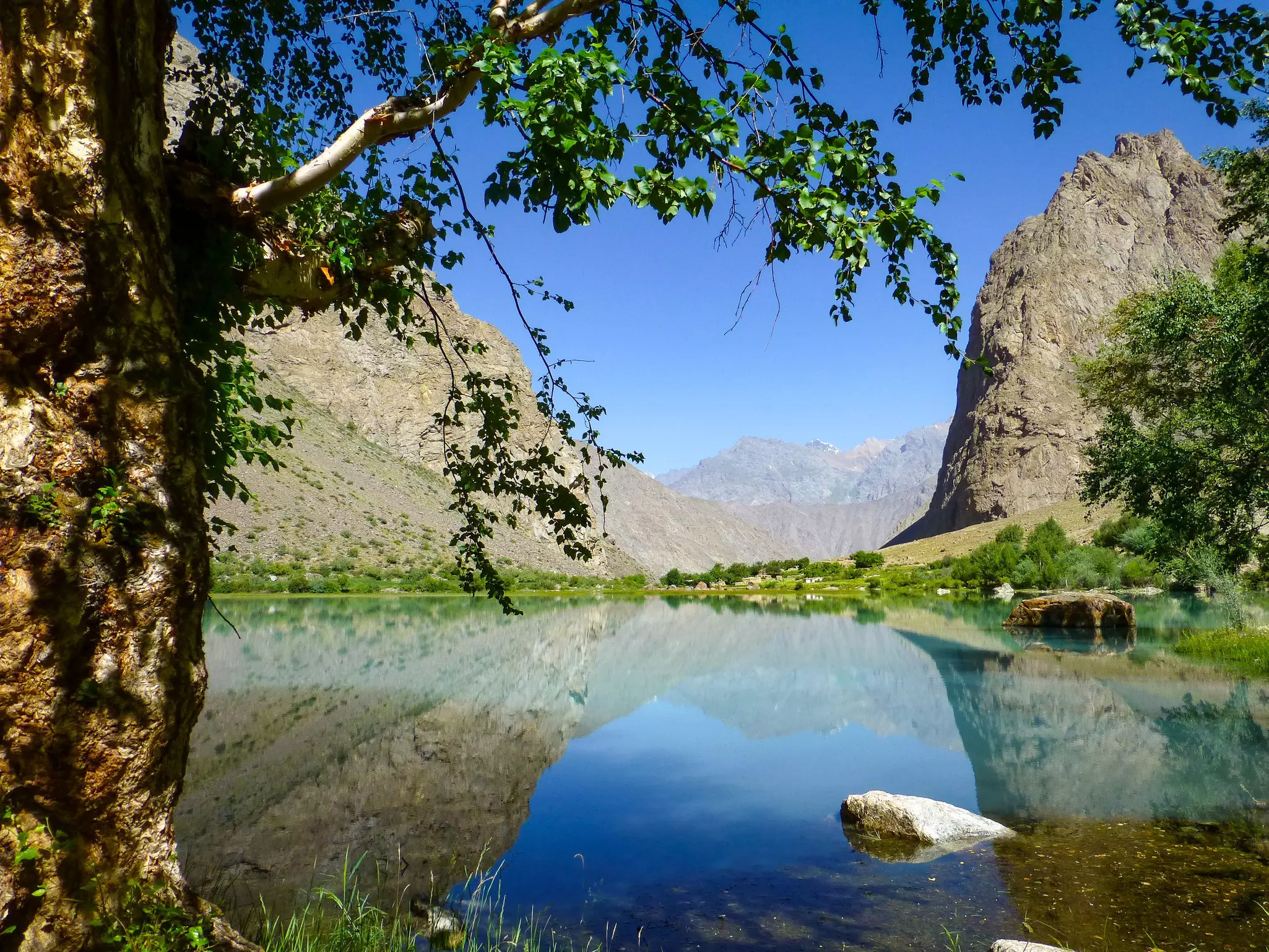 Teal water surrounded by jagged rocky mountains, Jizeu Valley, Kazakhstan