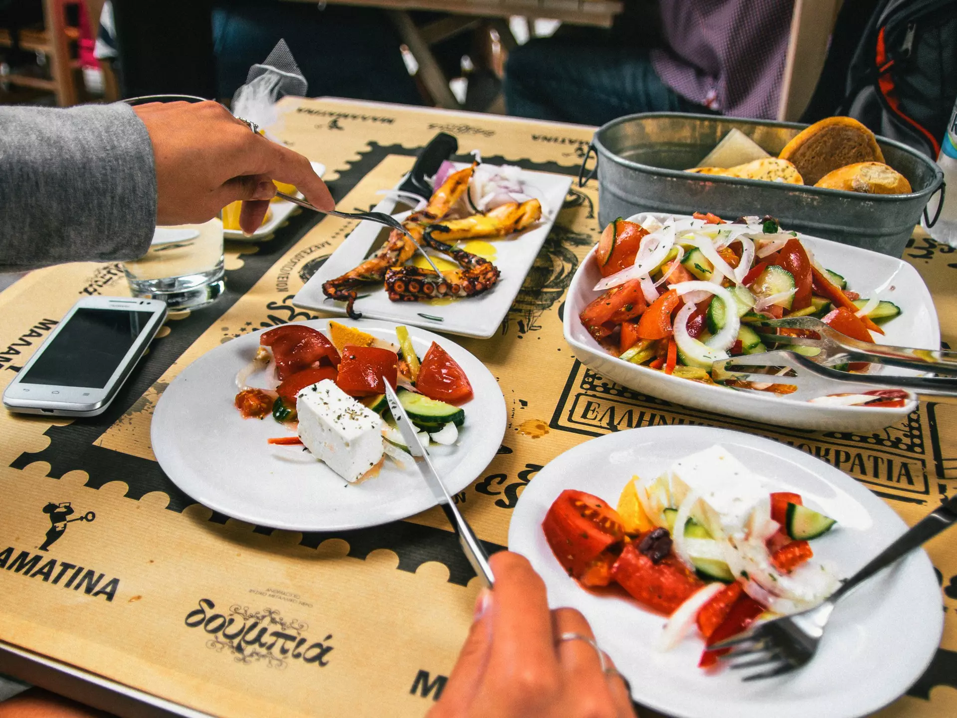 A large portion of Greek salad, grilled octopus and bread. 