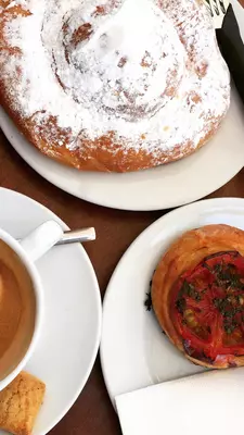 Coffee, tomato tarts and an ensaimada dusted with powdered sugar 
