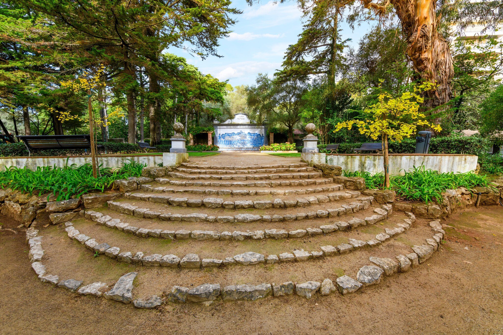 Wide terraced steps form a fan shape in a city park; a blue-tile fountain is at the top of the steps.