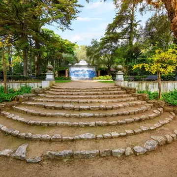 Wide terraced steps form a fan shape in a city park; a blue-tile fountain is at the top of the steps.