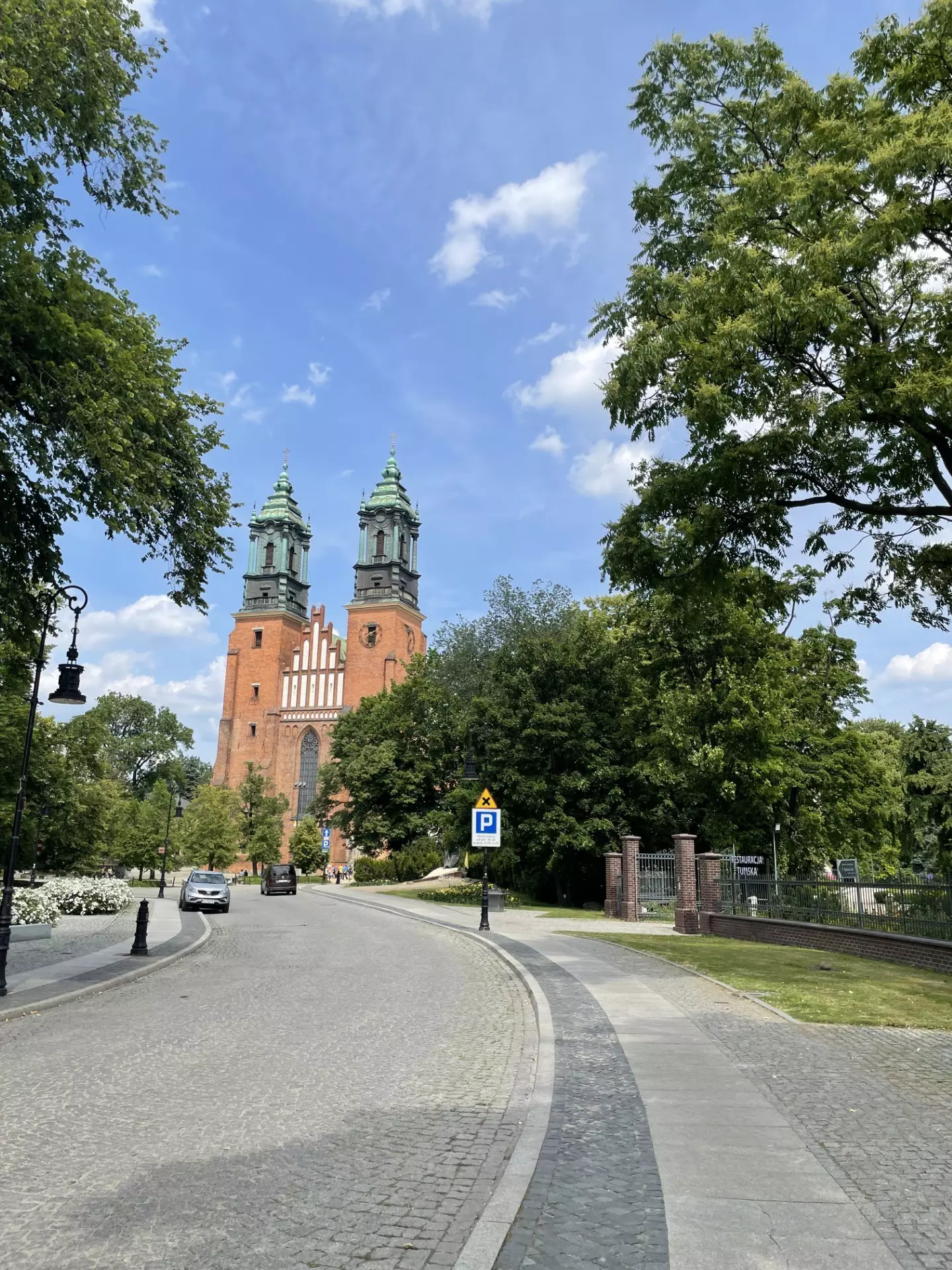 Stone road leading up to a brick building with ornate green towers