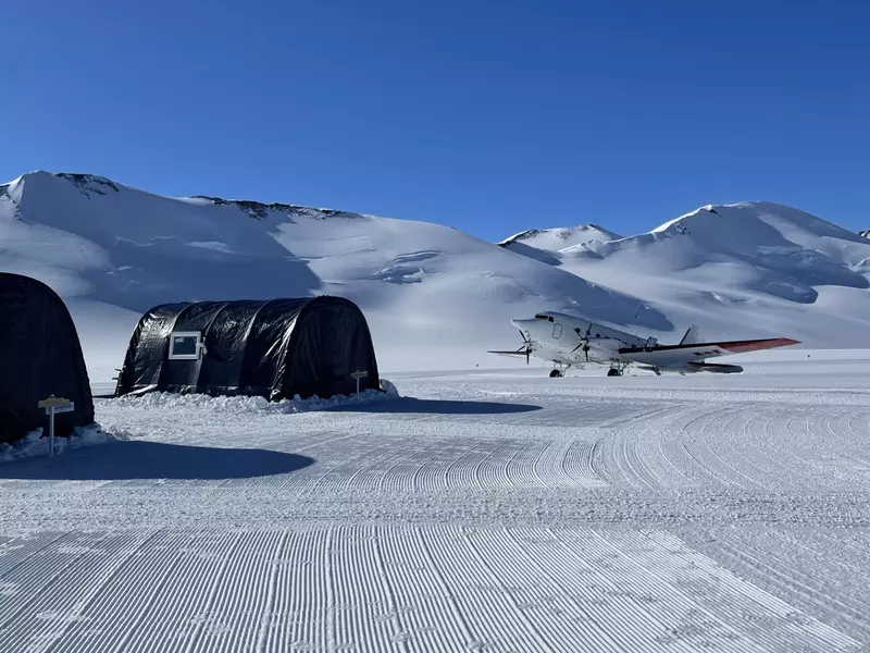 A small plane near a row of tents in snow