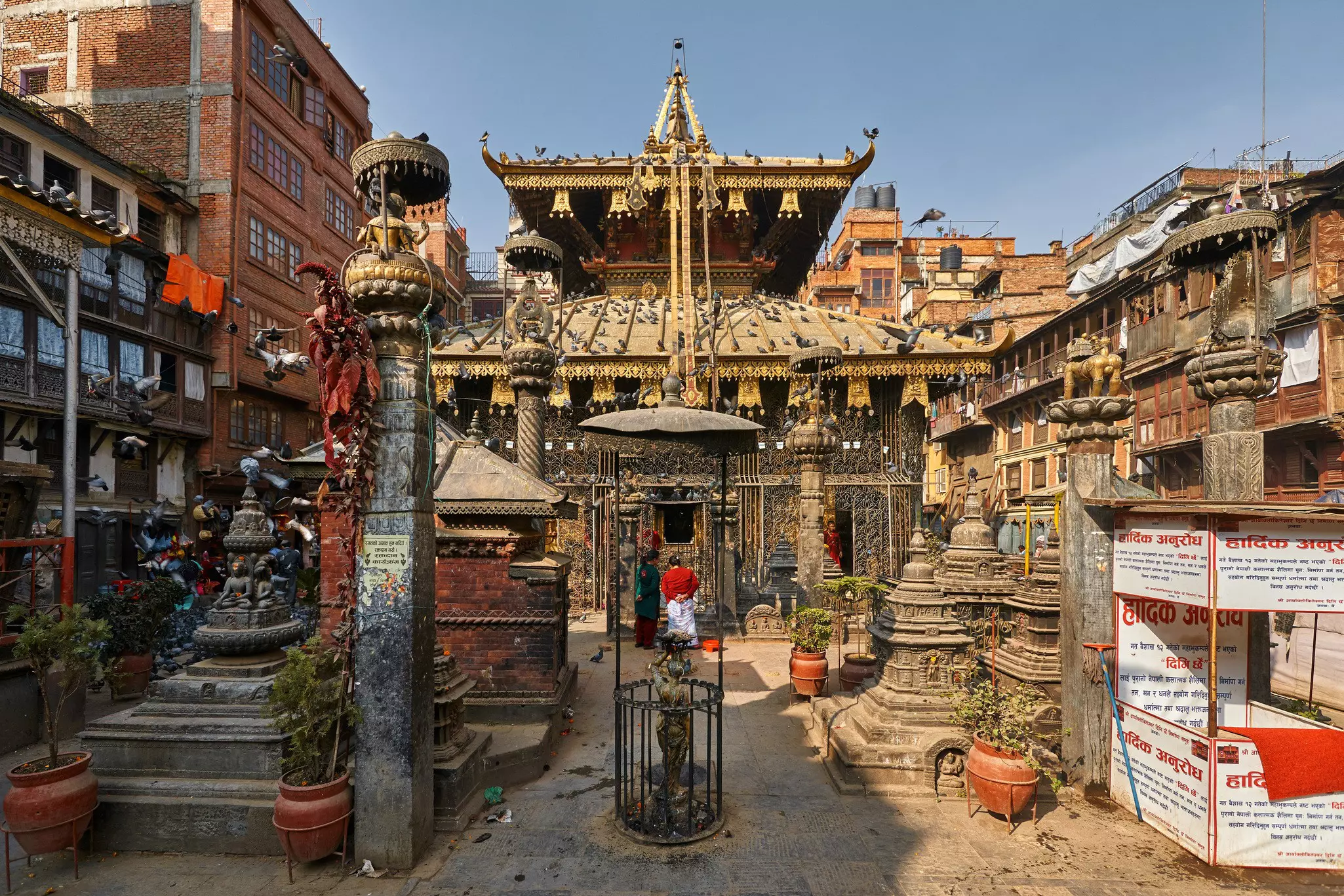 An ornate temple amid some taller, more modern buildings in the background