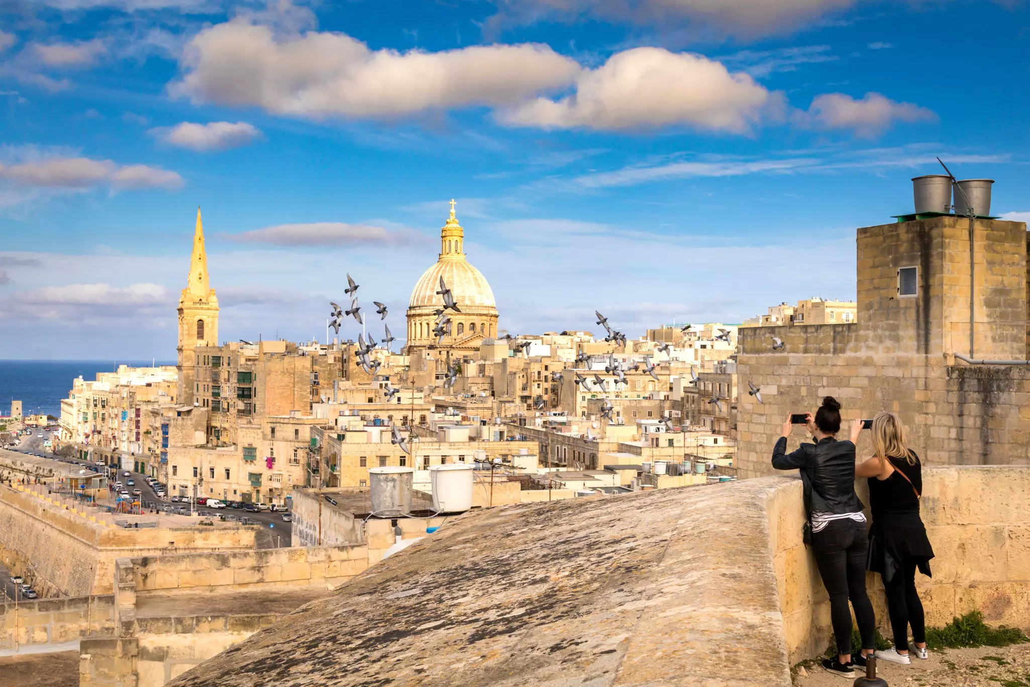 Two women tourists looking at hte skyline of Valletta, Malta