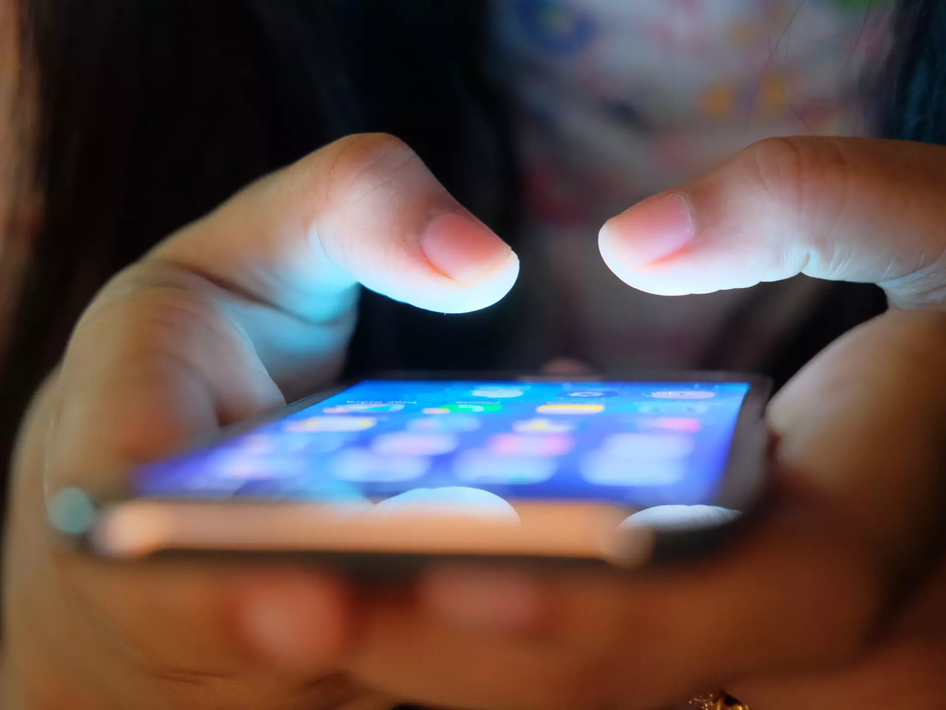 The menu of a smartphone is visible as the phone is held in a hand
