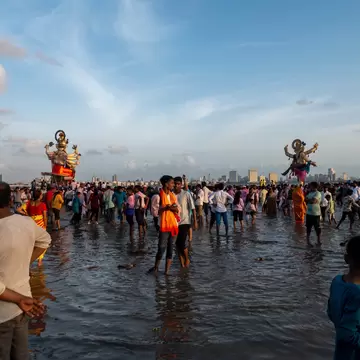 Large size Ganapati or Ganesha idol being carried to the sea for immersion at Girgaon Chowpatty. Mumbai, Maharashtra, India.