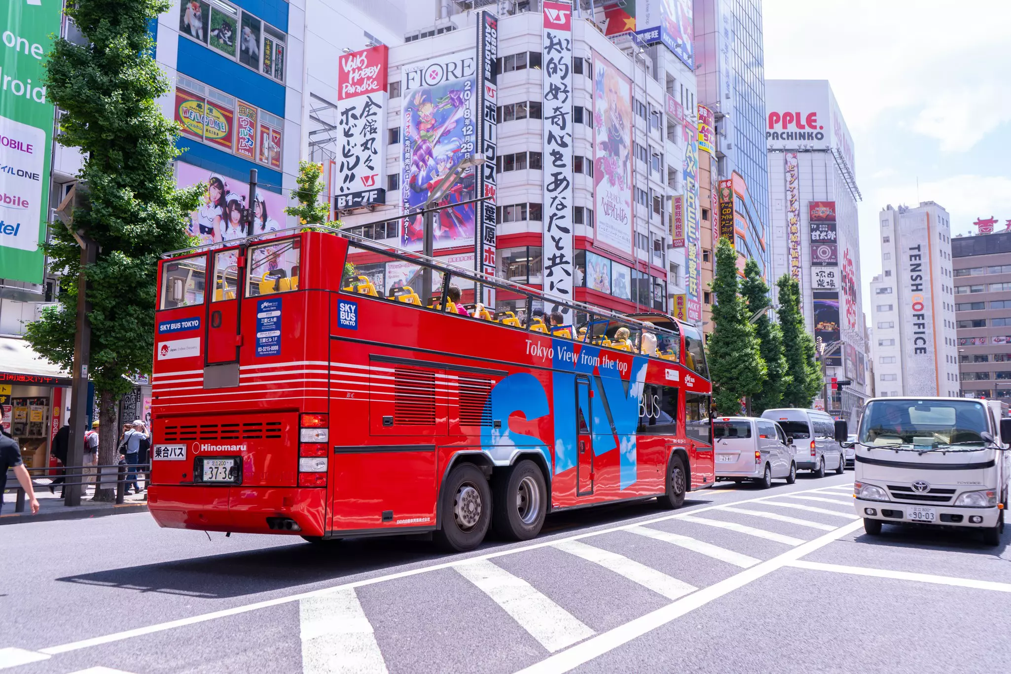 A sightseeing tour bus passes through the town of Akihabara in Japan.