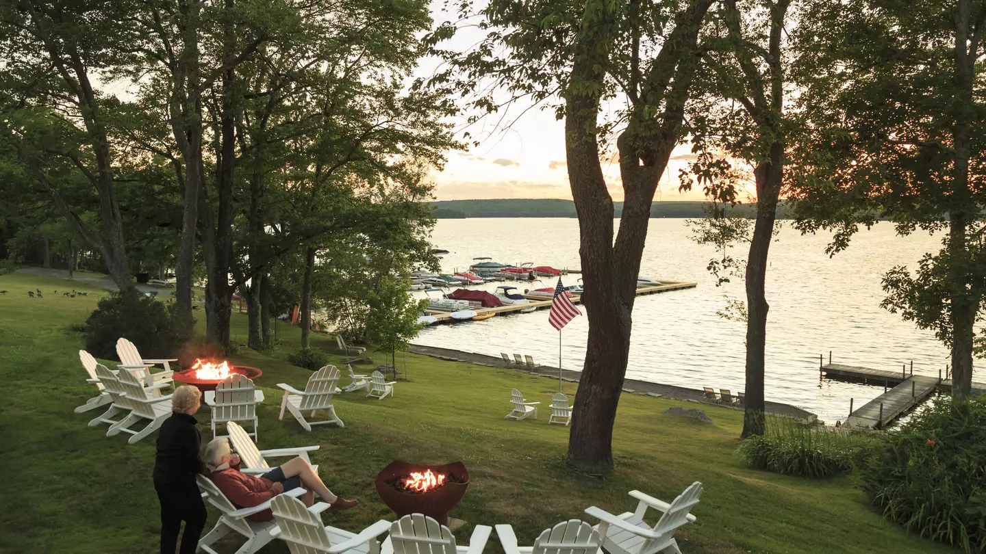 An older couple sit on the side of Lake Wallenpaupack watching the sun set