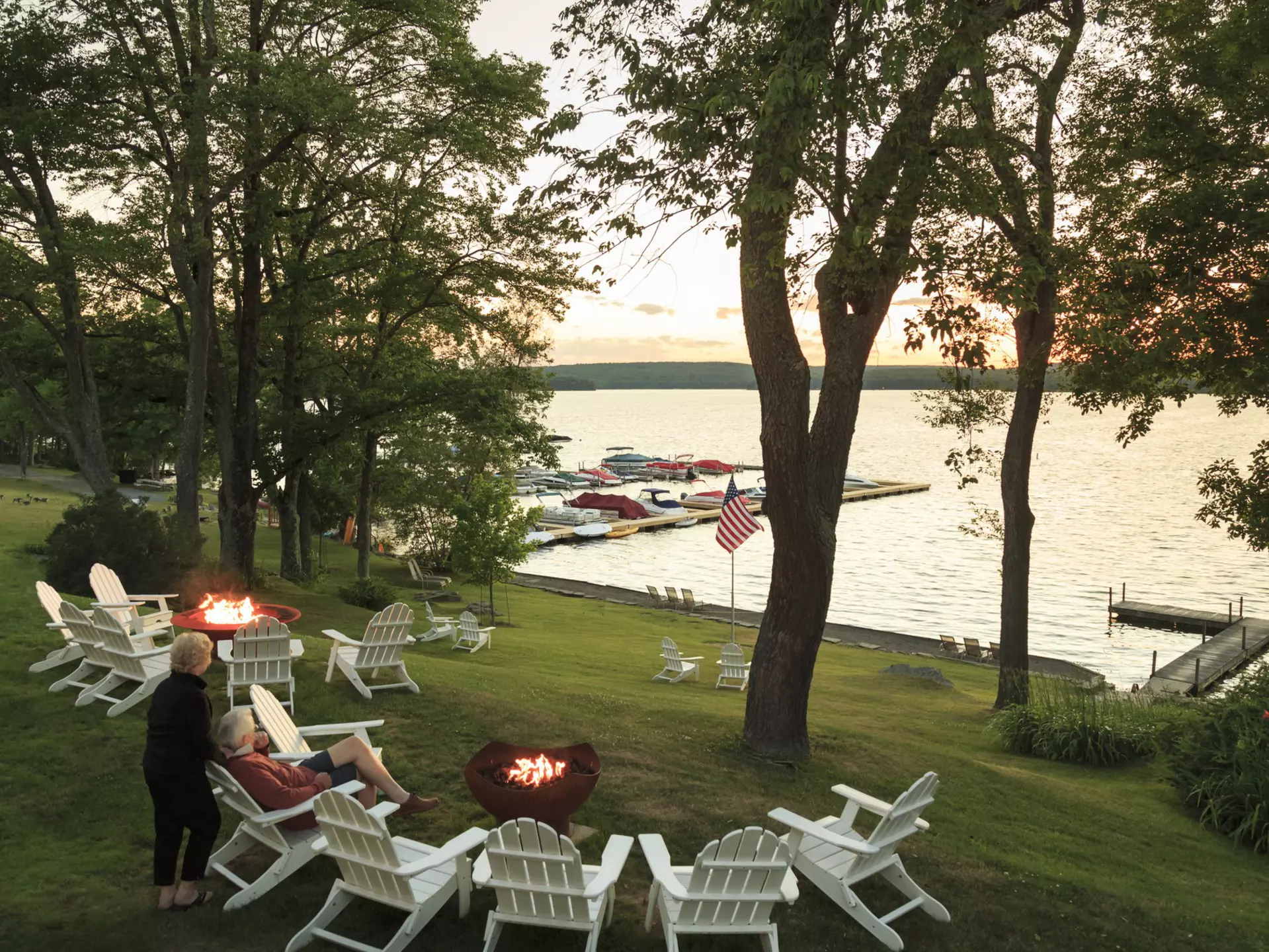 An older couple sit on the side of Lake Wallenpaupack watching the sun set