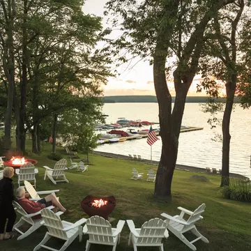 An older couple sit on the side of Lake Wallenpaupack watching the sun set