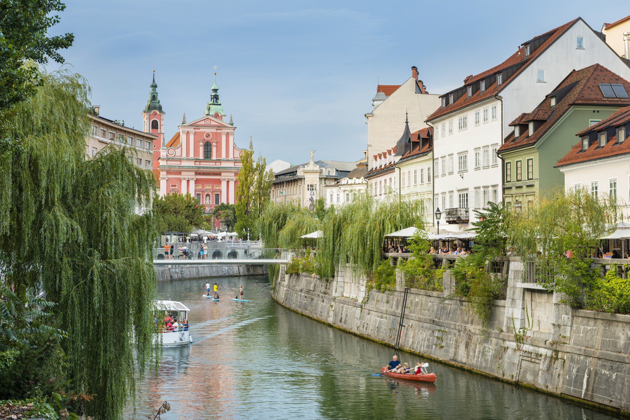 KayakBoats and paddle boarders travel down the tree-lined Ljubljanica River, which flows through the centre of Ljubljana.