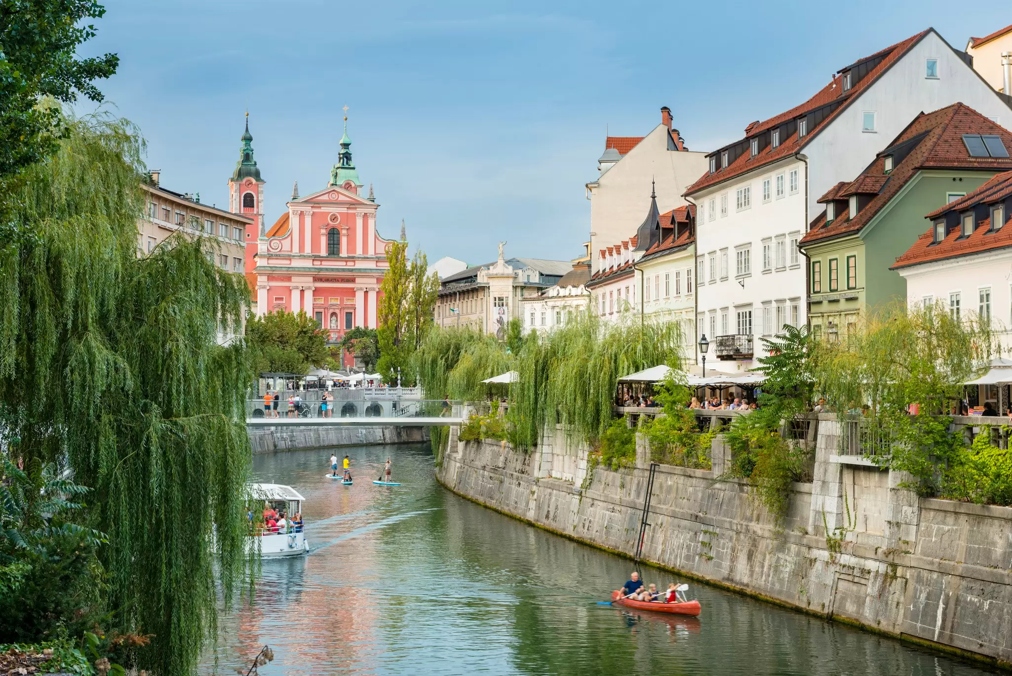 People enjoying the Ljubljanica River on boats and paddleboards in the center of Ljubljana, Slovenia. 