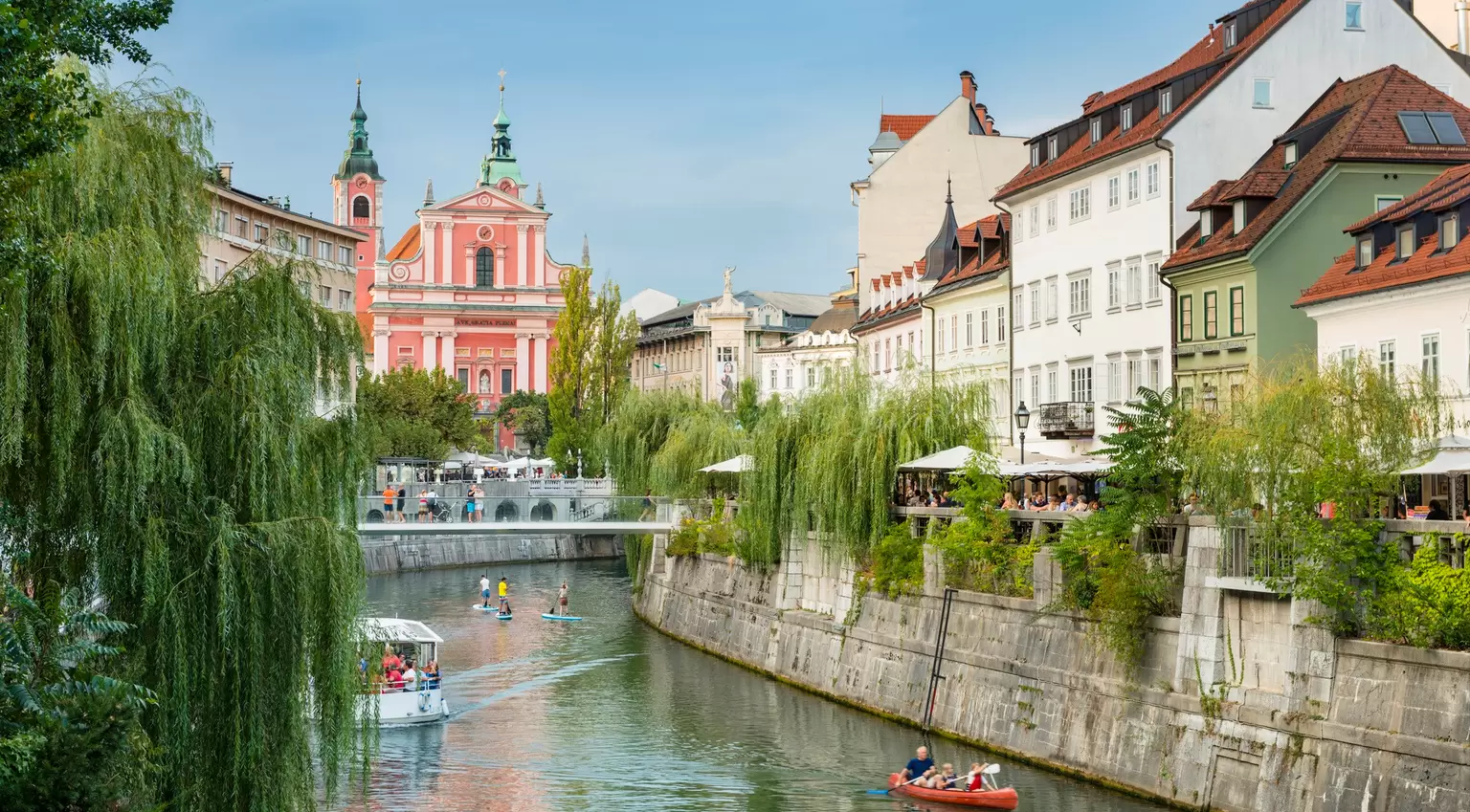 People enjoying the Ljubljanica River on boats and paddleboards in the center of Ljubljana, Slovenia. 